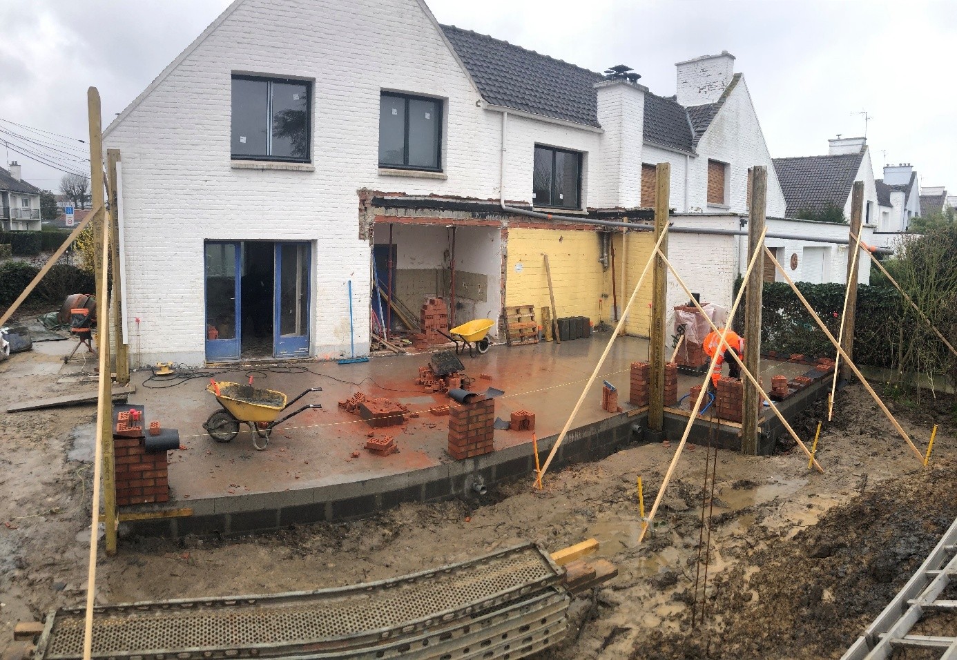 Maison blanche en construction avec des briques et des outils